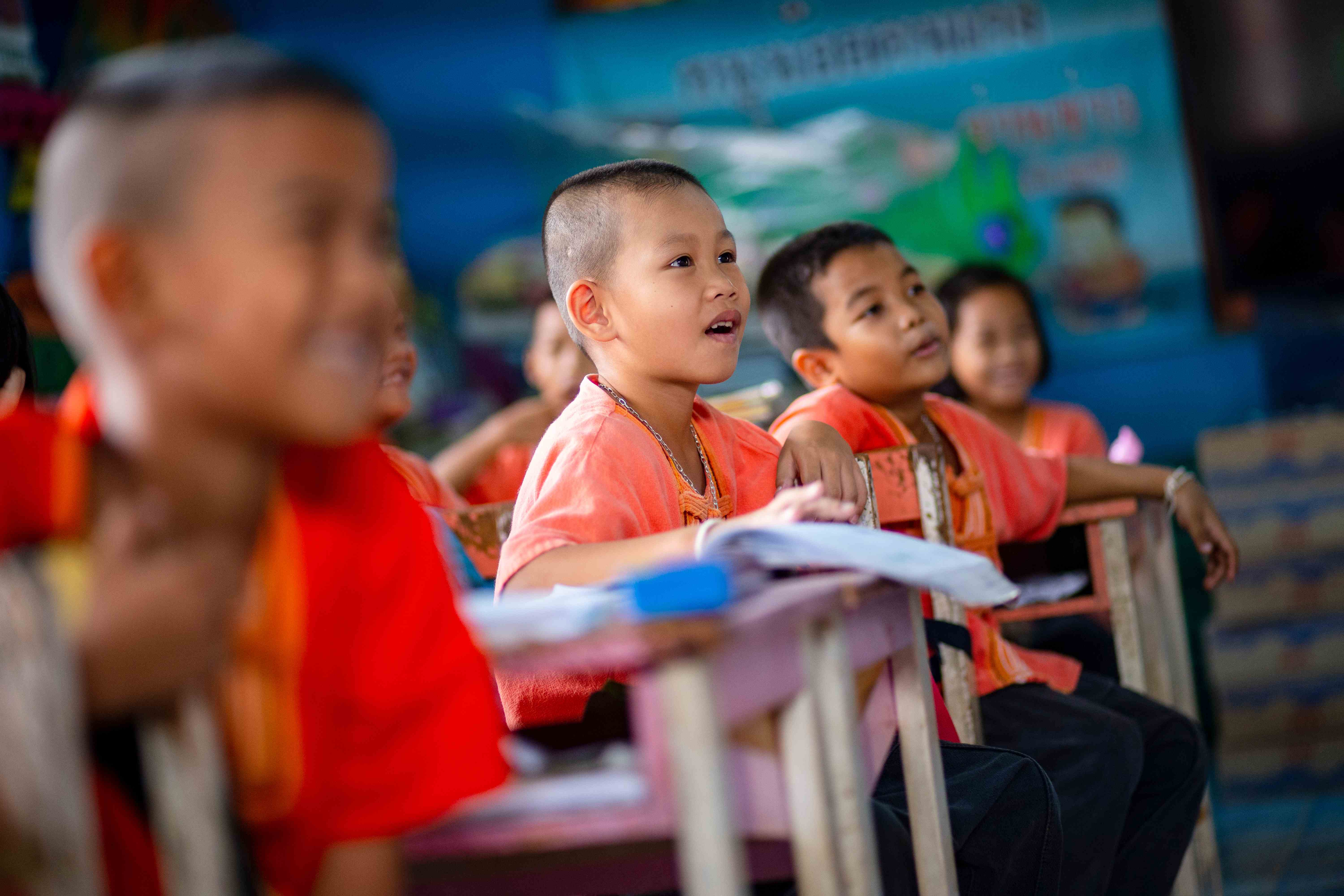 Kinder in einer Schule in Thailand betrachten etwas außerhalb des Bildes und haben Spaß  (Bildquelle: Jakob Studnar)