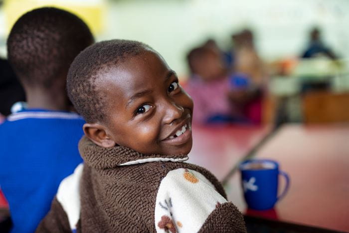 Ein Junge aus Kenia blickt lachend über seine rechte Schulter. (Quelle: Lars Heidrich)