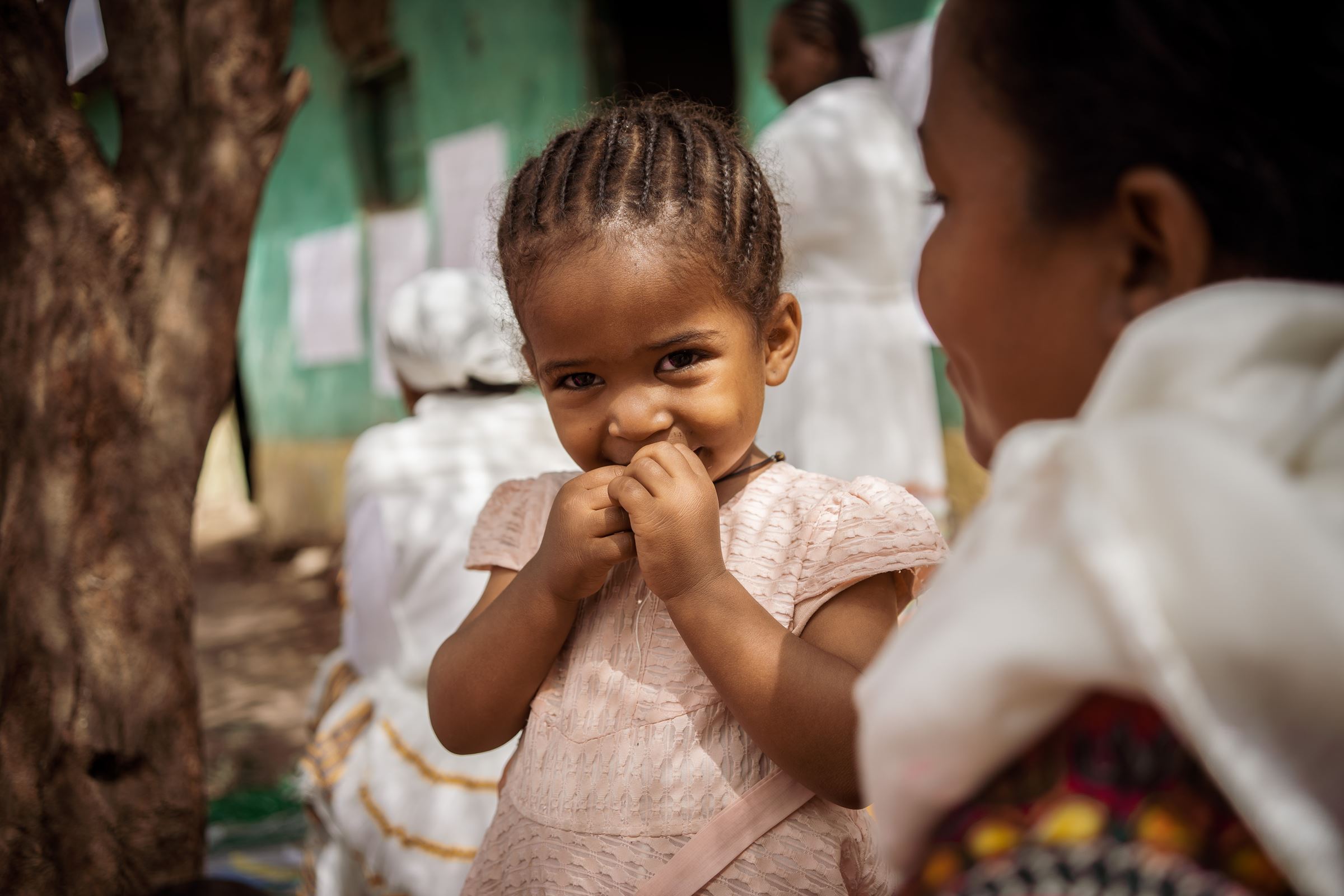 Ein kleines Mädchen aus Äthiopien hält schüchtern eine Hand vors Gesicht. (Quelle: Jakob Studnar)