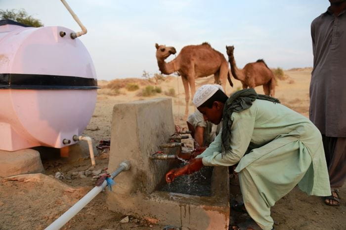 Ein Mann wäscht sich die Hände mit sauberem Wasser an einem Brunnen. (Quelle: Christine Idems)