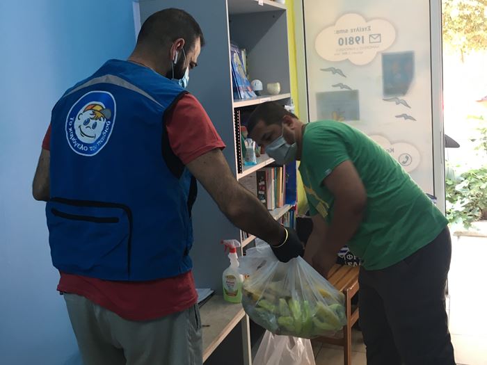 Ein Mann, ein Geflüchteter im Griechenland, erhält Lebensmittel. (Quelle: Lena Bakatsi)