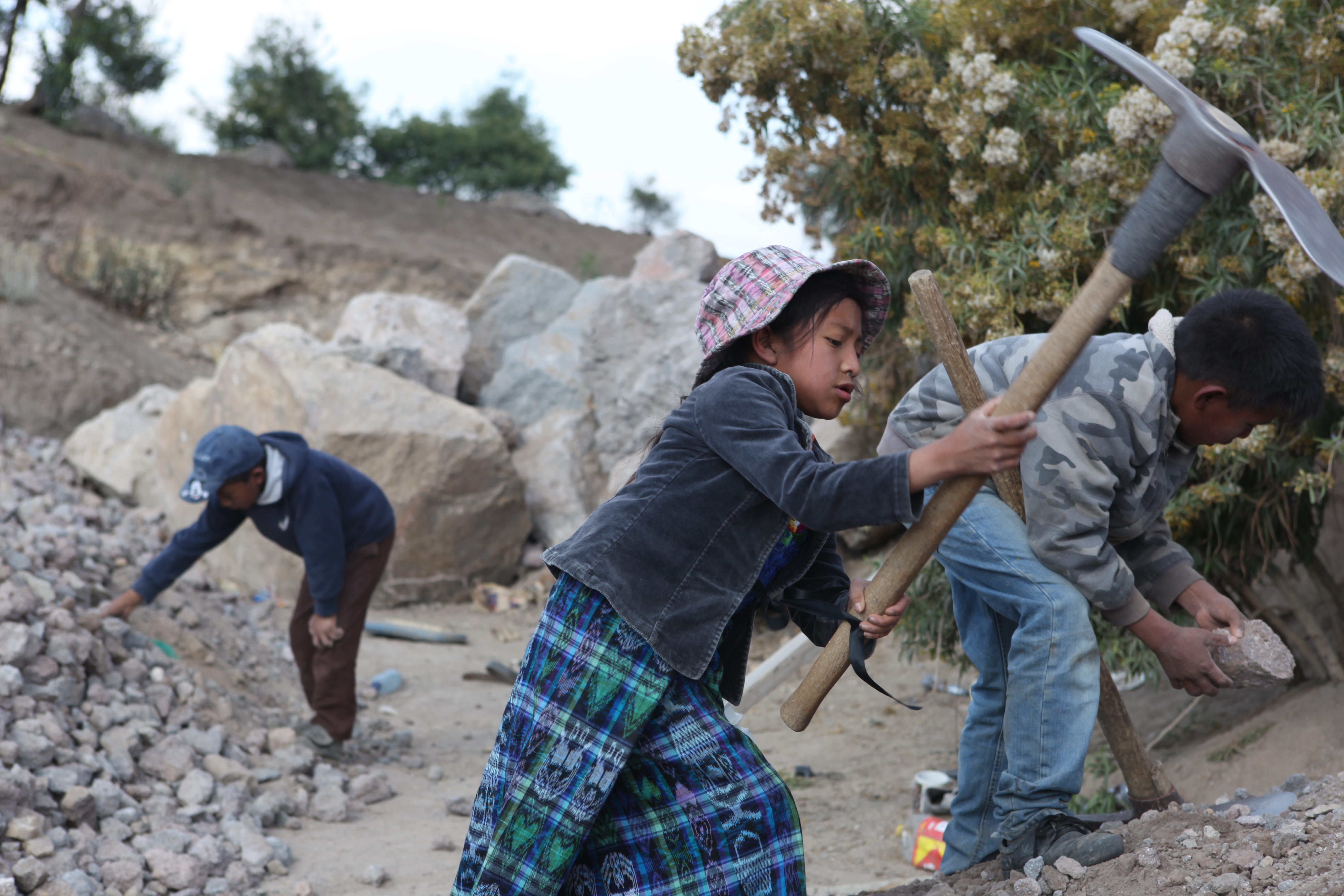 Ein kleines Mädchen hackt mit einer Spitzhacke in einem Steinbruch in Guatemala Steine. (Quelle: Malte Pfau)