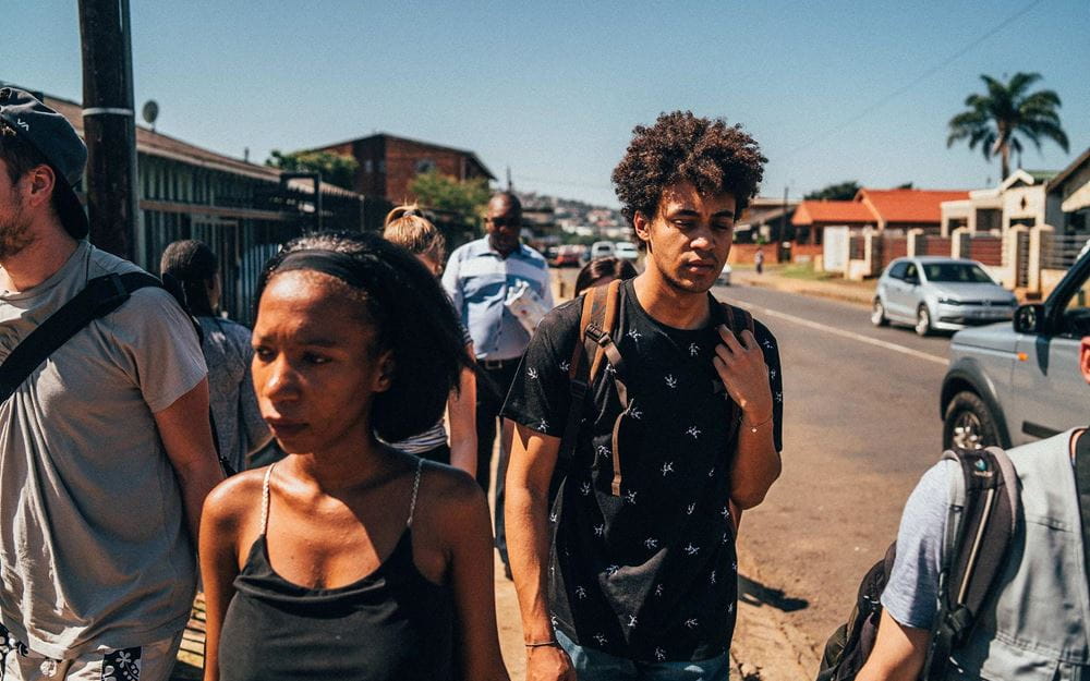Reportage: Auf den Straßen von Südafrika; Foto: Sozialarbeiterin Lungi in Gruppe von Menschen (Quelle: Dillan White / Kindernothilfe) Reportage: Auf den Straßen von Südafrika; Foto: Sozialarbeiterin Lungi in Gruppe von Menschen (Quelle: Dillan White / Kindernothilfe)