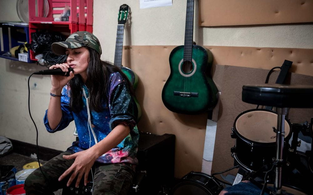 Reportage Guatemala; Foto: Frau mit Mikrofon, sitzend (Quelle: Fabian Strauch / Kindernothilfe)