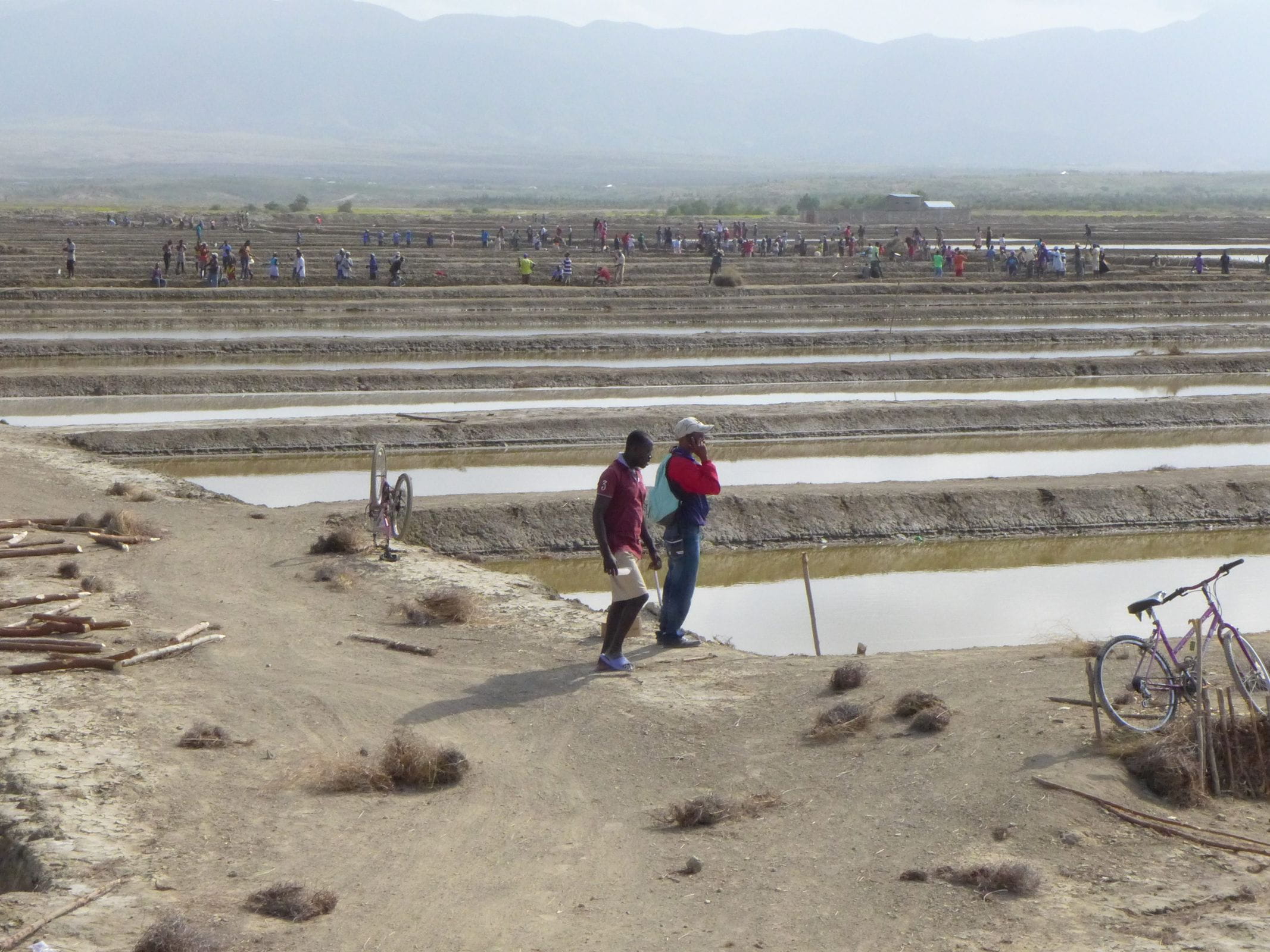 Reportage Haiti: Gute Nachrichten von der Salinen-Anlage; Foto: Blick über Salinenanlage mit Personen (Quelle: Erhard Stückrath / Kindernothilfe)