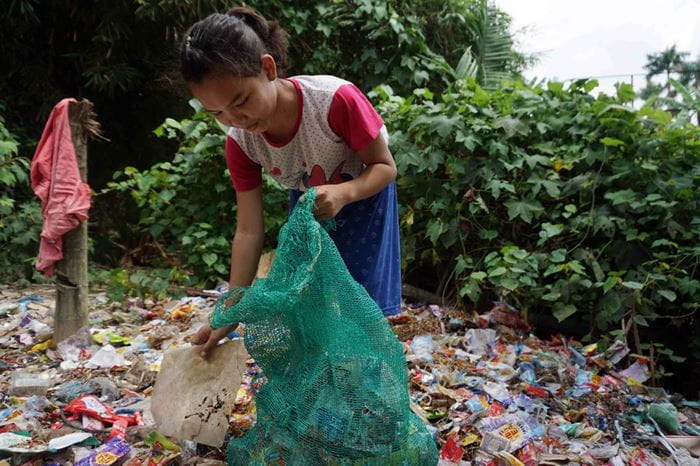 Ein Mädchen stopft Recyclingmüll in einen Sack (Quelle: Christiane Dase)