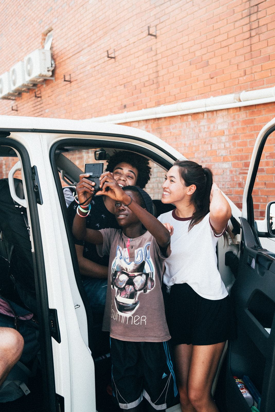 Shanti und Dillan mit afrikanischem Jungen beim Selfie