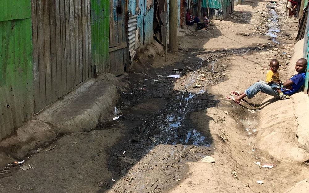 Reportage Kenia: Ein Alltag auf neun Quadratmetern; Foto: Blick auf schlammigen Weg zwischen Wellblechhütten  (Quelle: Dan Zoubek / Kindernothilfe) 