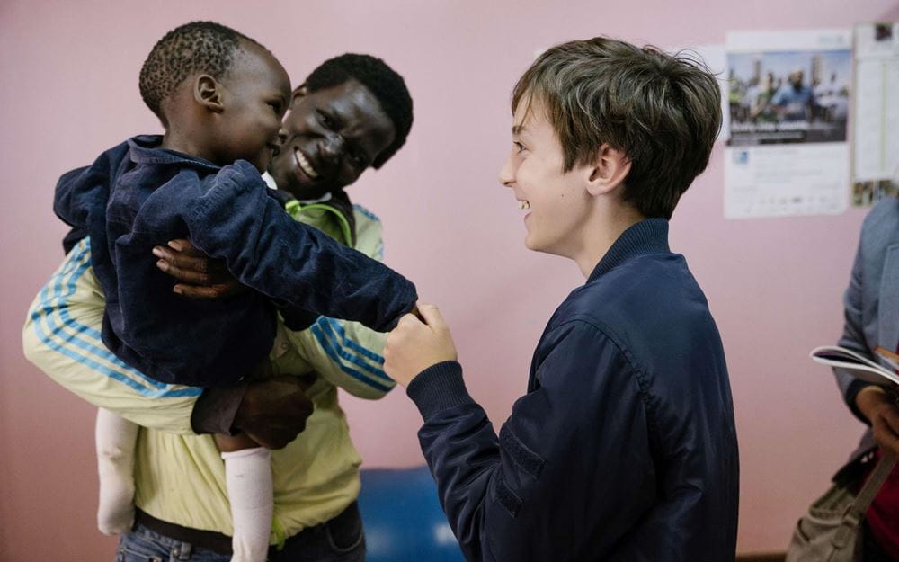 Reportage Kenia: Ein Alltag auf neun Quadratmetern; Foto: Jacob hält Hand eines Kindes (Quelle: Dan Zoubek / Kindernothilfe) 
