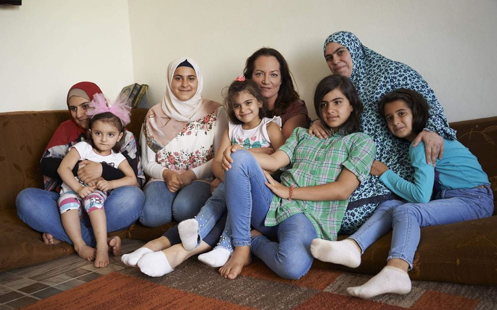 Reportage Libanon; Foto: Gruppenbild mit Natalia Wörner und  einer Familie (Quelle: Ulrich Gernhardt / Kindernothilfe)
