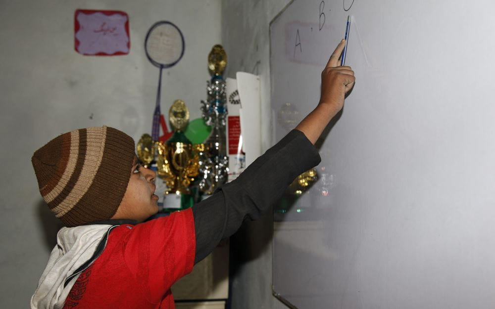 Reportage Pakistan: Das Leben riskieren, um zu überleben; Foto: Junge schreibt an Tafel (Quelle: Christian Herrmanny / Kindernothilfe) Reportage Pakistan: Das Leben riskieren, um zu überleben; Foto: Junge schreibt an Tafel (Quelle: Christian Herrmanny / Kindernothilfe)