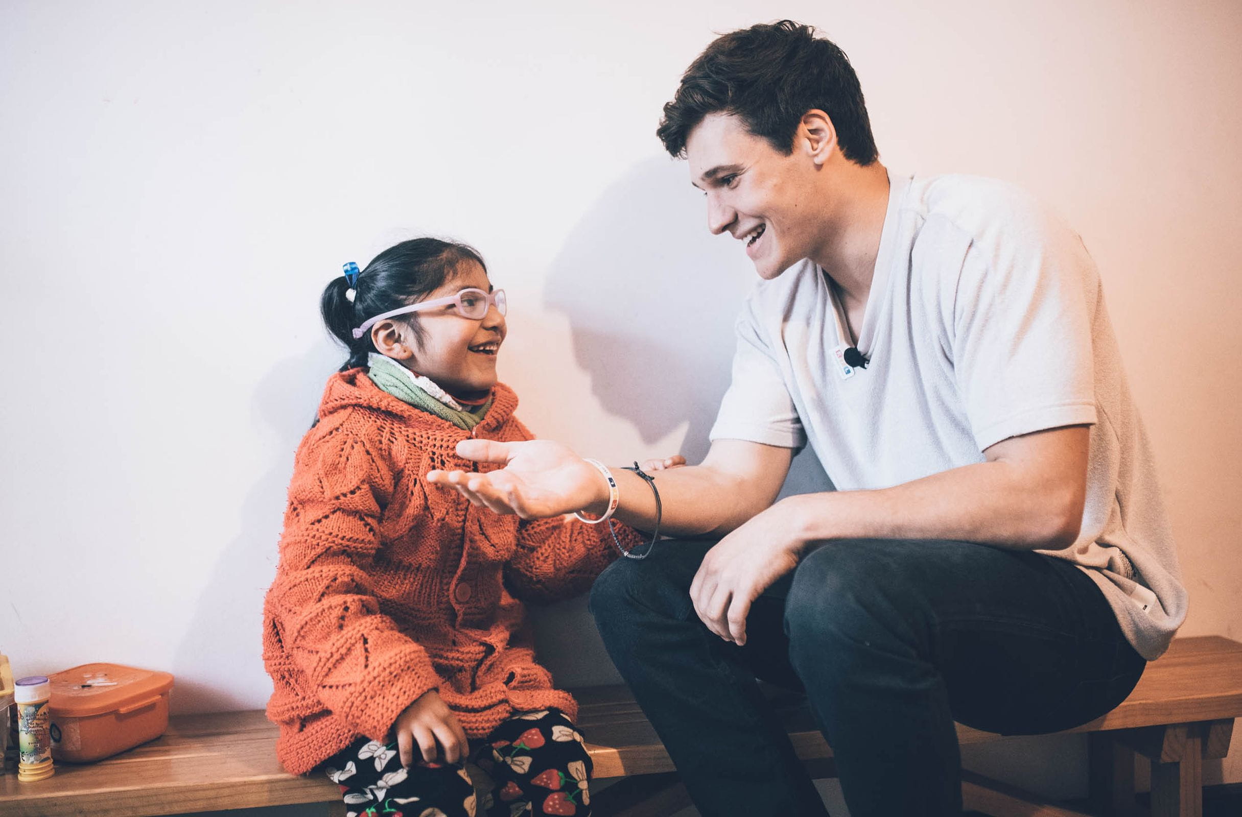 Reportage Peru: Kindernothilfe-Botschafter Wincent Weiss besucht ein Projekt; Foto: Wincent Weiss und ein Kind sitzen nebeneinander (Quelle: Christoph Köstlin / Kindernothilfe)