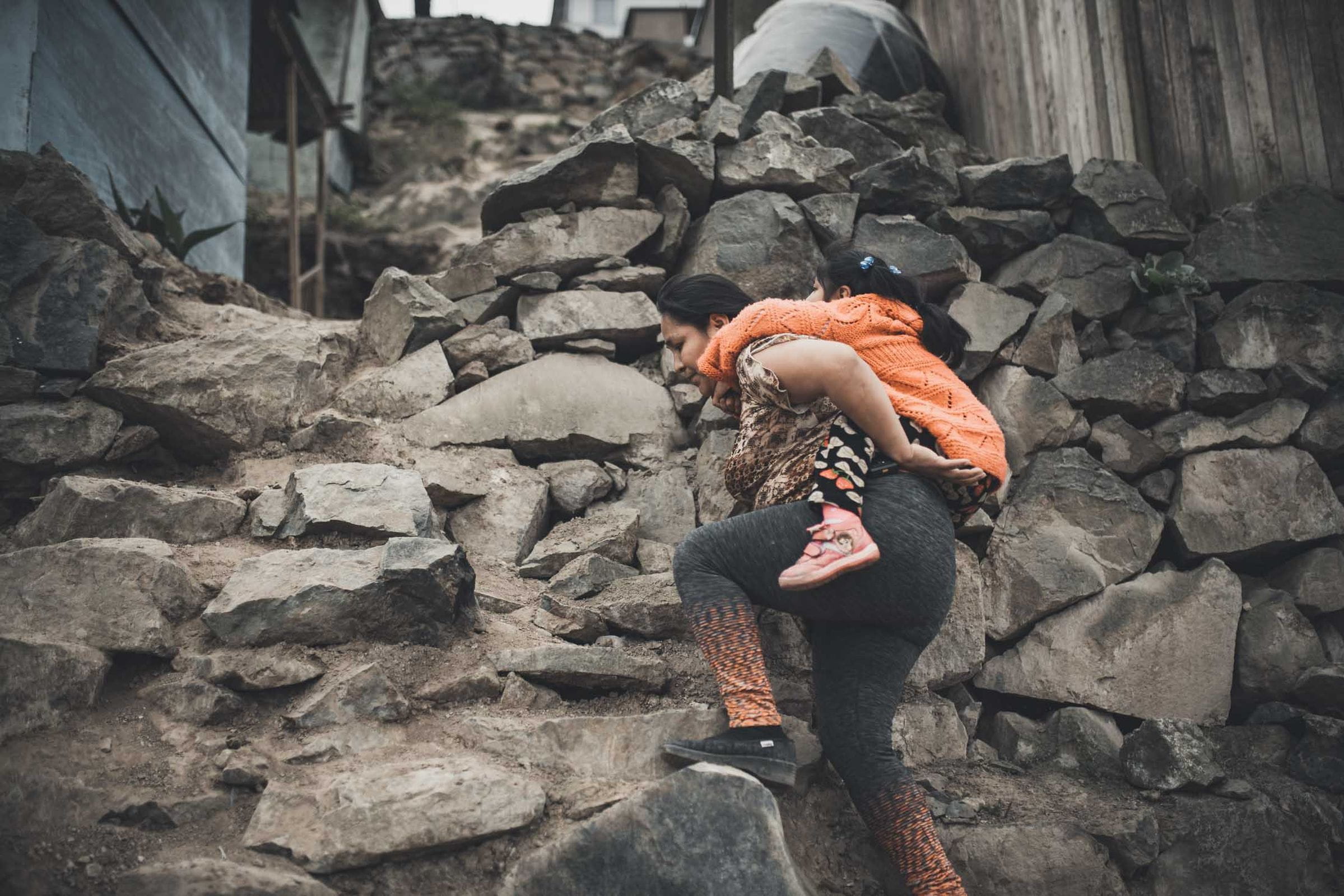 Reportage Peru: Kindernothilfe-Botschafter Wincent Weiss besucht ein Projekt; Foto: Mutter trägt Tochter auf dem Rücken (Quelle: Christoph Köstlin / Kindernothilfe)