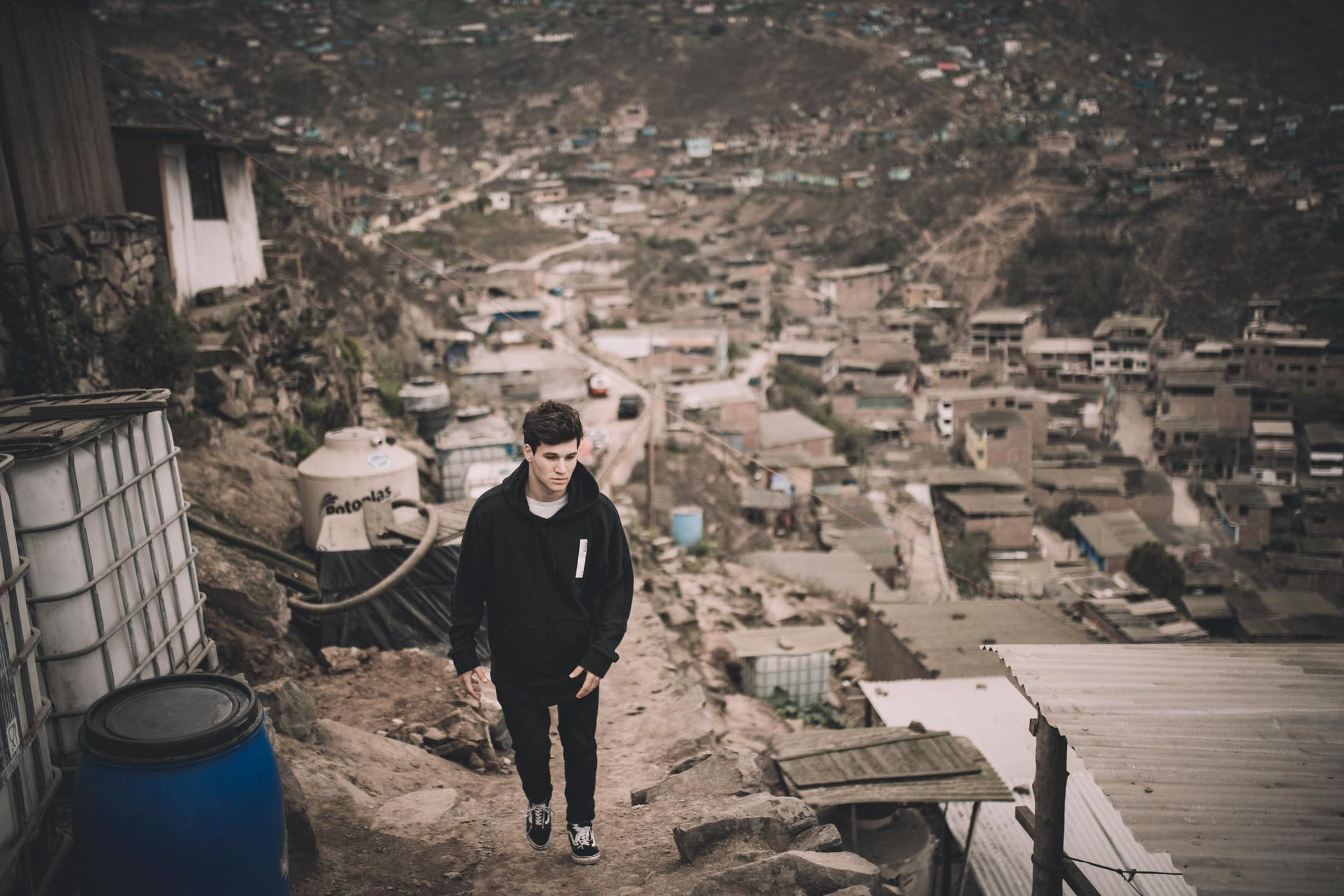Reportage Peru: Kindernothilfe-Botschafter Wincent Weiss besucht ein Projekt; Foto: Wincent Weiss auf einem Weg in einem Armenviertel (Quelle: Christoph Köstlin / Kindernothilfe)