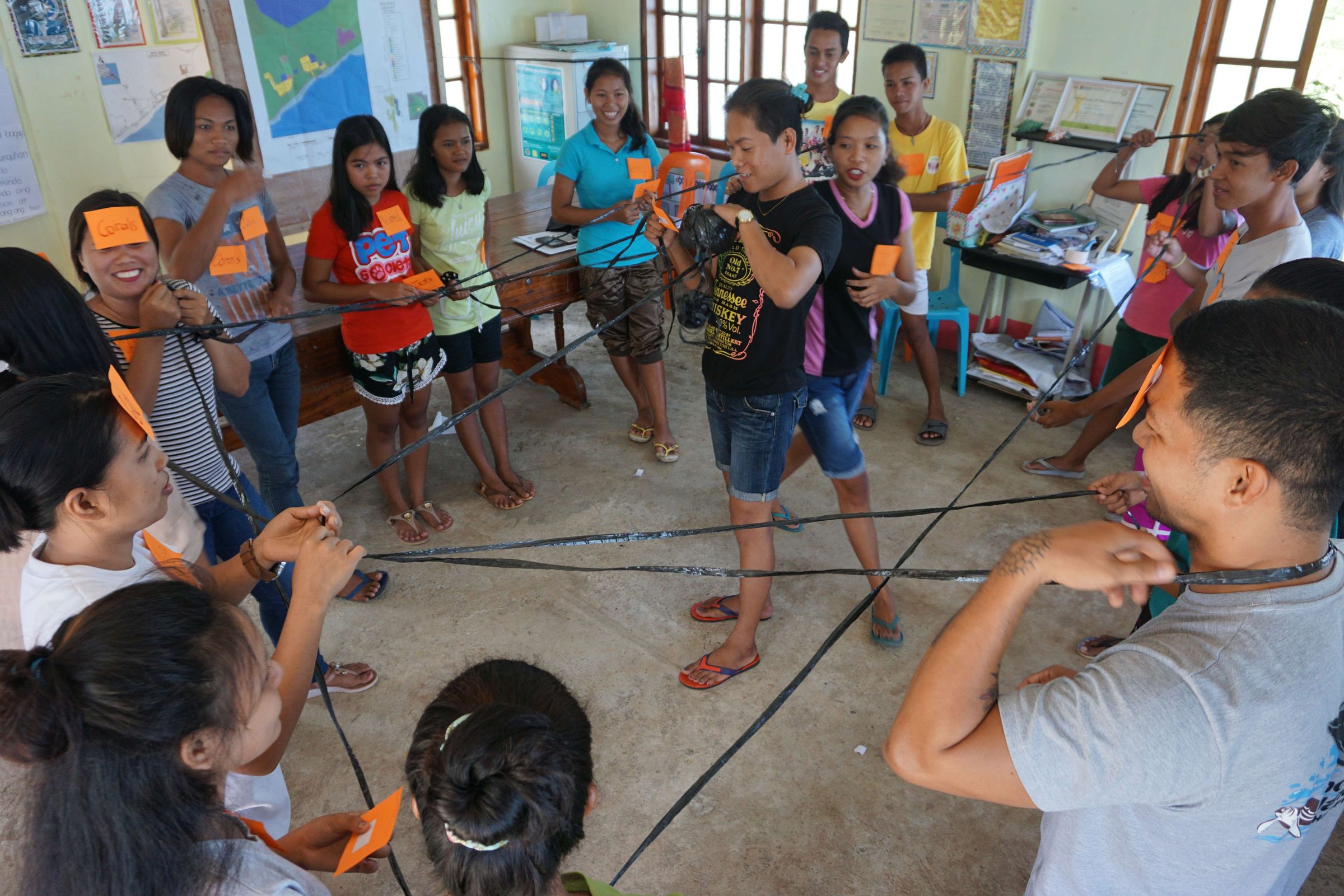 Reportage Philippinen: Ein Taifun als Weckruf; Foto: Gruppe steht im Kreis um zwei Personen, sie sind mit Bändern verbunden  (Quelle: Lorenz Töpperwien / Kindernothilfe)
