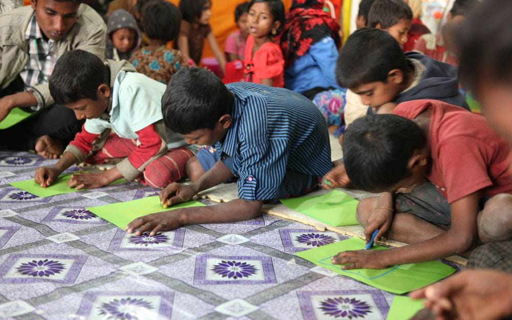 Reportage: Rohingya in Bangladesch; Foto: Kinder im Schutzzentrum malen etwas (Quelle: Christian Herrmanny / Kindernothilfe)