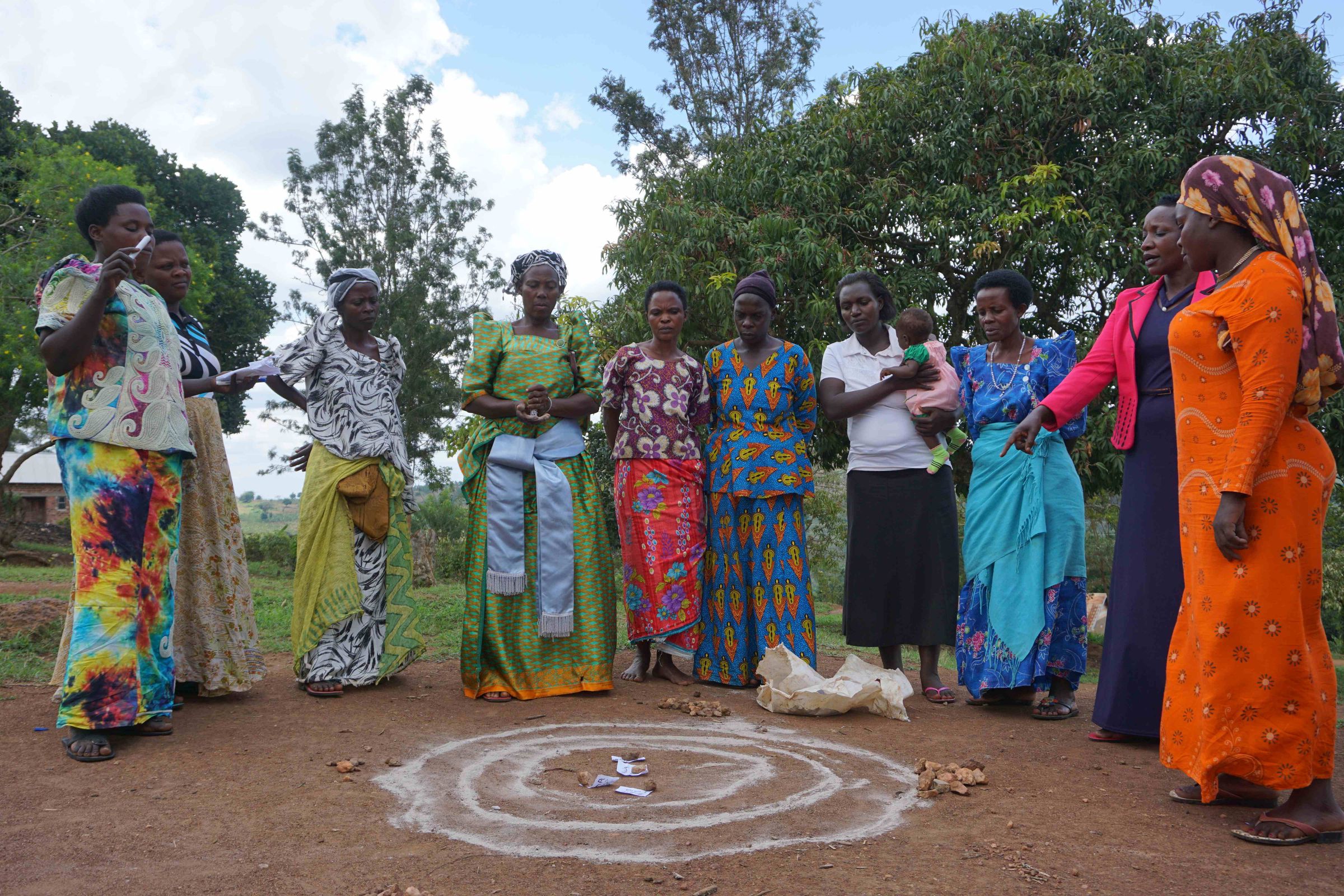 Reportage Uganda: Aufschwung am Äquator; Foto: Frauen einer Selbsthilfegruppe stehen im Halbkreis (Quelle: Ludwig Grunewald / Kindernothilfe)