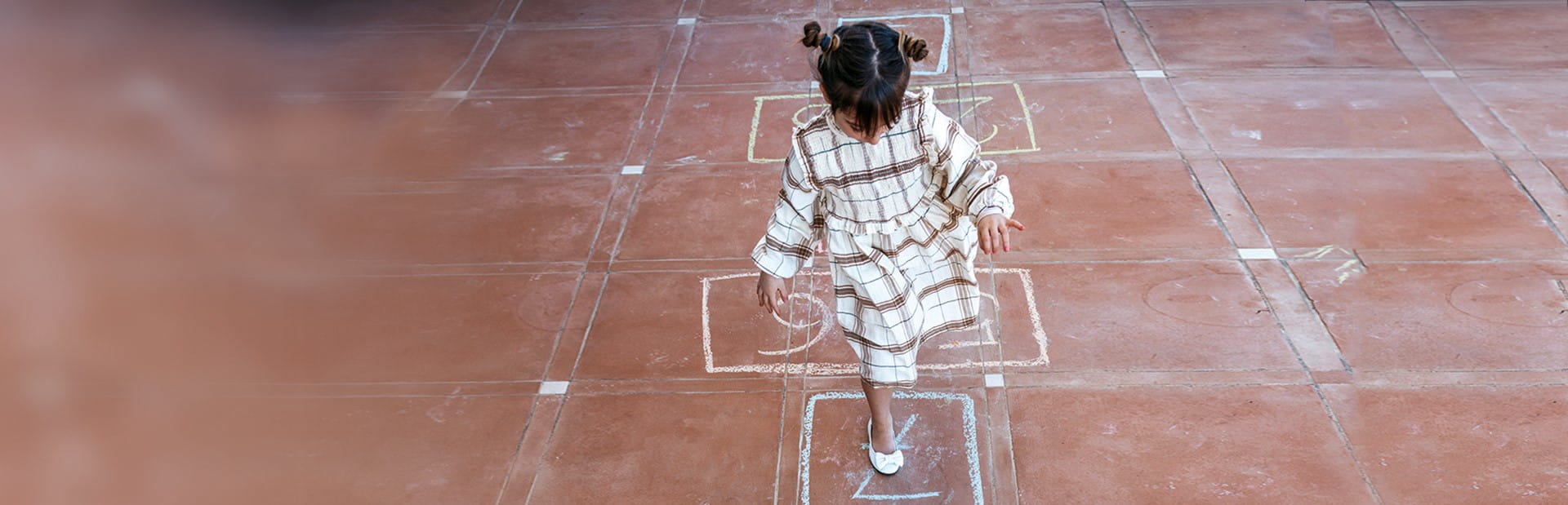 Ein Mädchen hüpf auf einem Bein. 