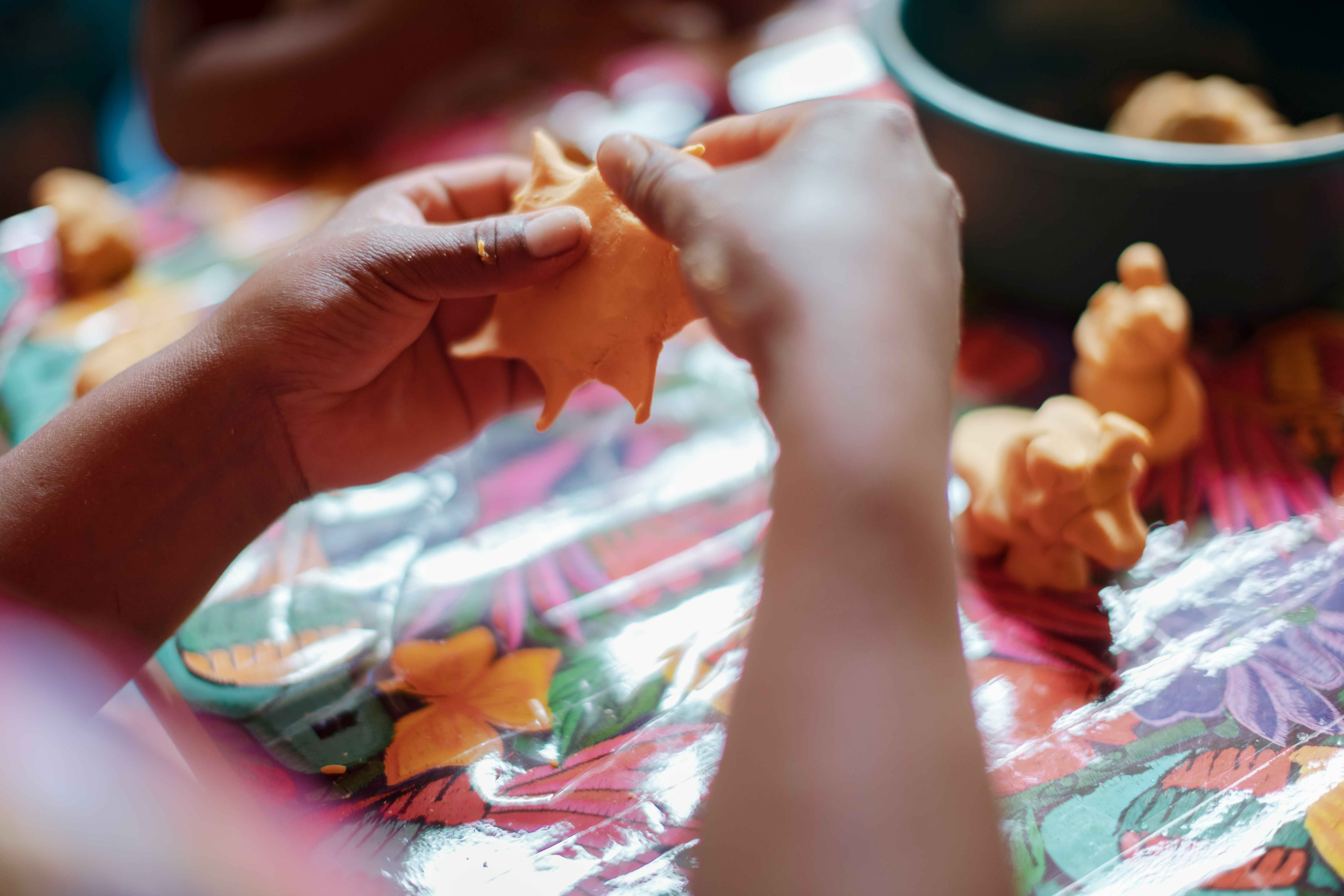 Kinderhände formen einen Stern aus gelber Knete. (Quelle: Jakob Studnar)