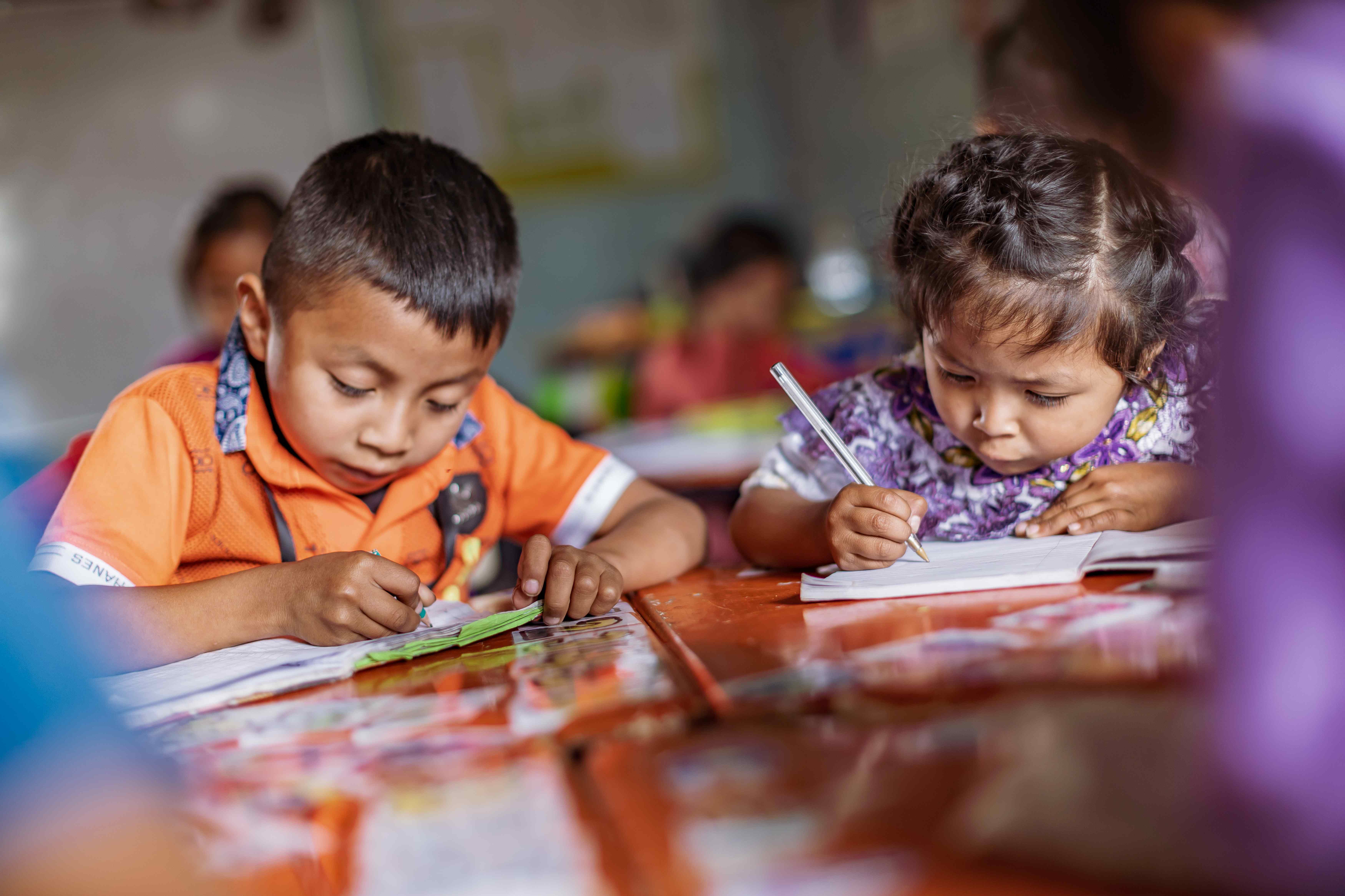 Zwei Vorschulkinder aus Guatemala beugen sich konzentriert über ihre Schreibhefte. (Quelle: Jakob Studnar) Zwei Vorschulkinder aus Guatemala beugen sich konzentriert über ihre Schreibhefte. (Quelle: Jakob Studnar)