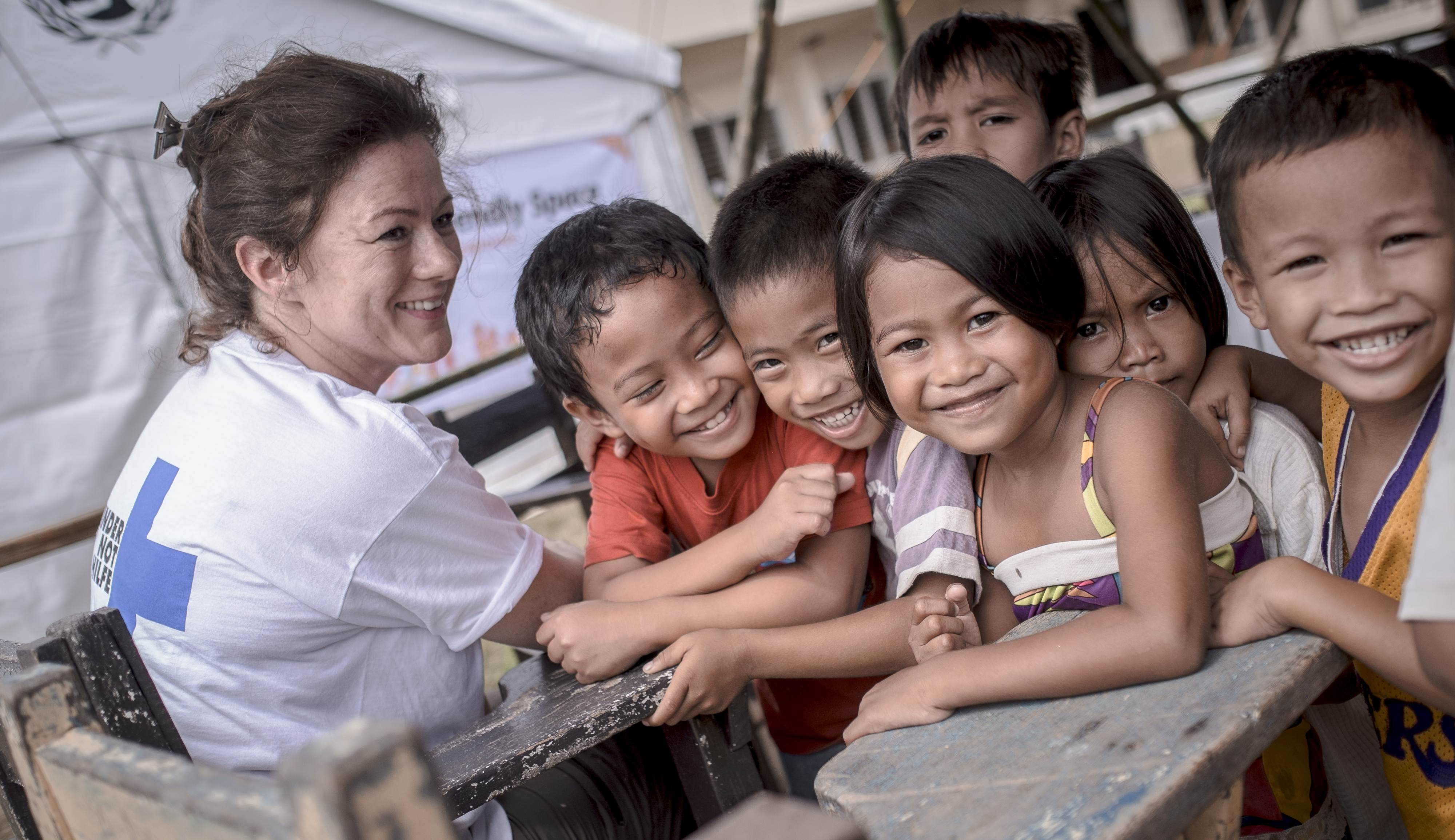 Eine Mitarbeiterin der Kindernothilfe unterhält sich nach dem Taifun Haiyan mit Kindern in einem Kinderzentrum. (Quelle: Jakob Studnar)