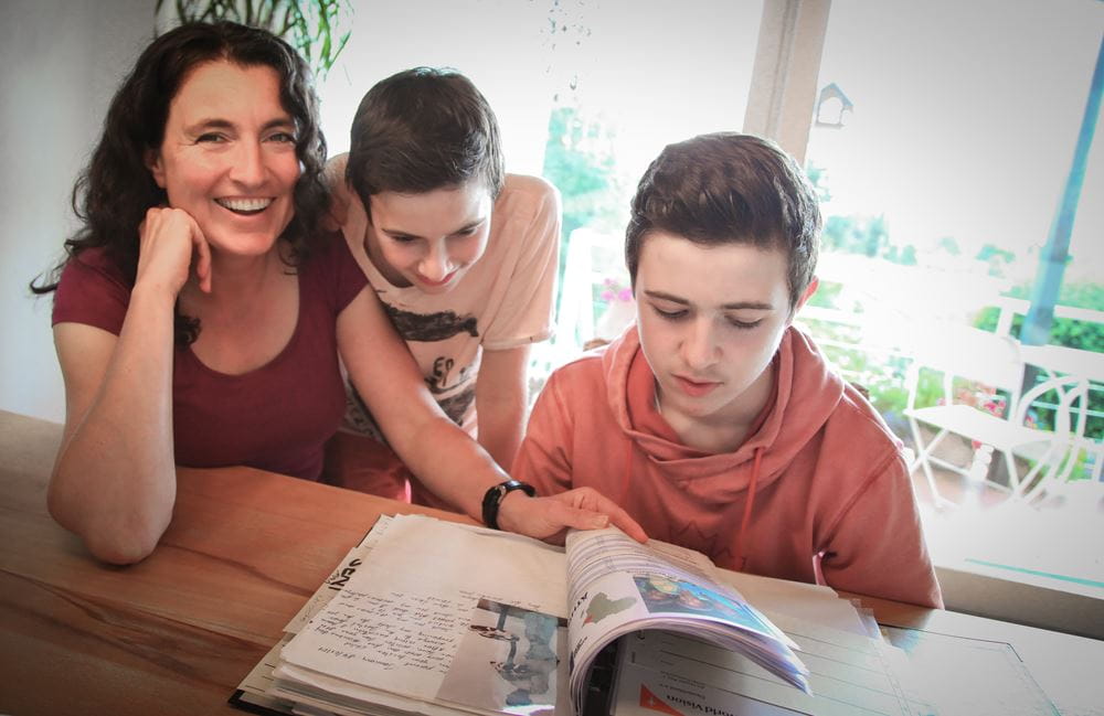 Sabine Herrmann mit ihren beiden Söhnen über die Briefe der Patenkinder gebeugt. (Quelle: Ralf Krämer) Sabine Herrmann mit ihren beiden Söhnen über die Briefe der Patenkinder gebeugt. (Quelle: Ralf Krämer)