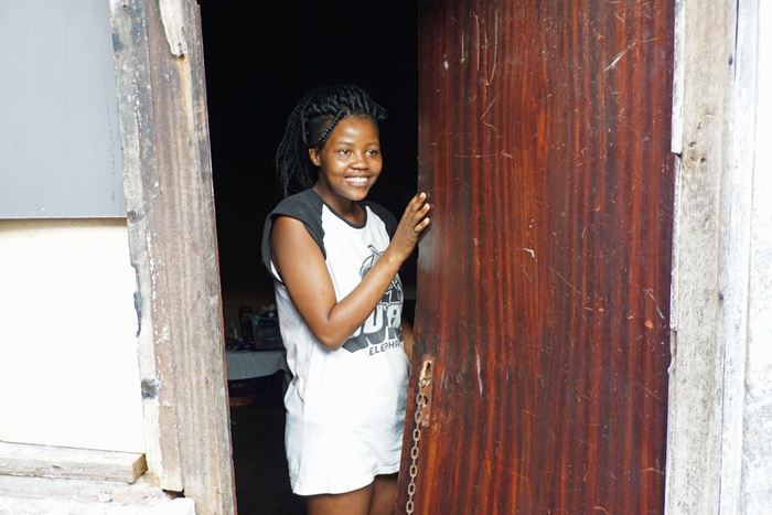 Straßenkind Amahie in der Tür der Bauruine, in der sie lebt