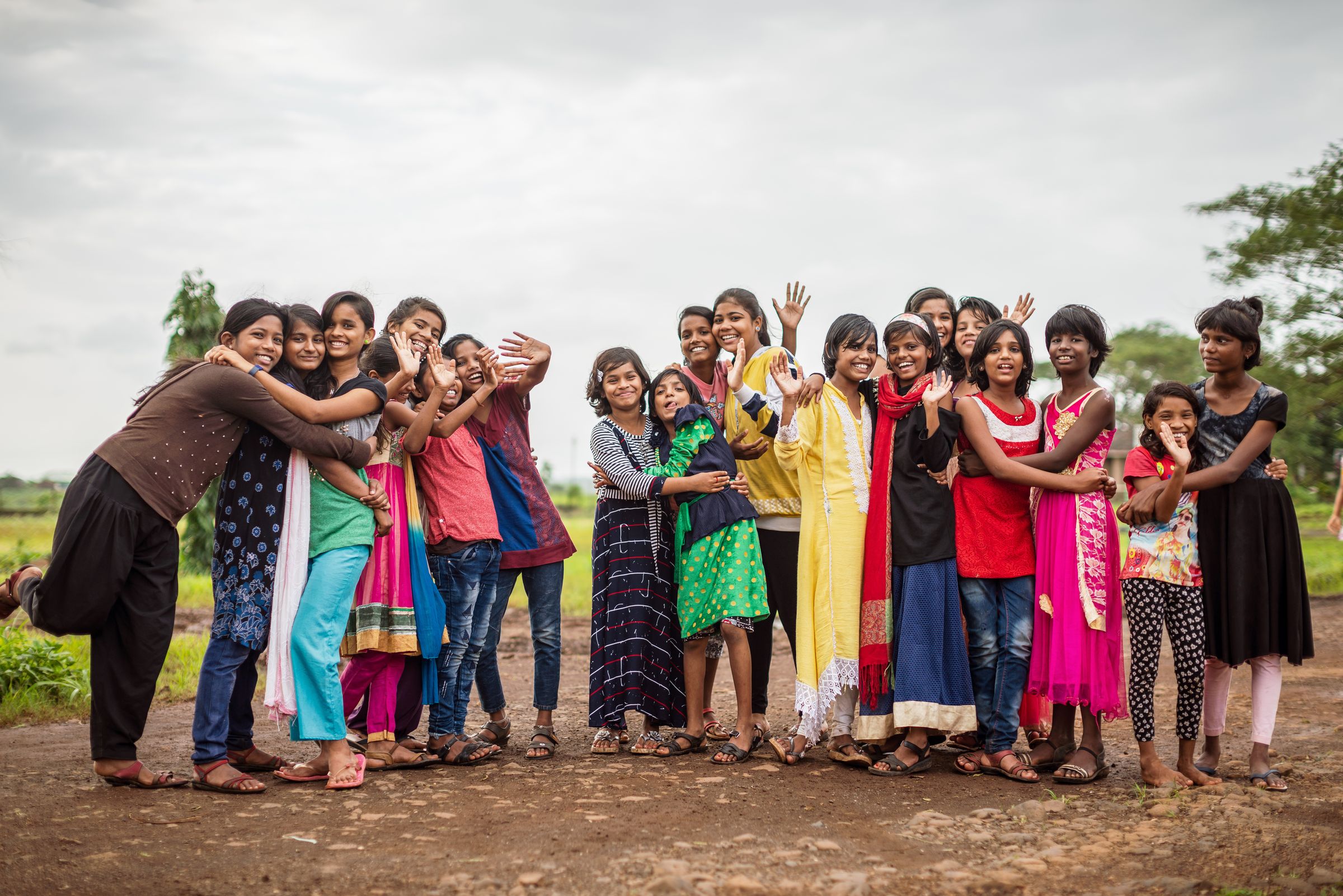 Eine Gruppe indischer Mädchen steht sich umarmend vor Bäumen. (Quelle: Jakob Studnar)