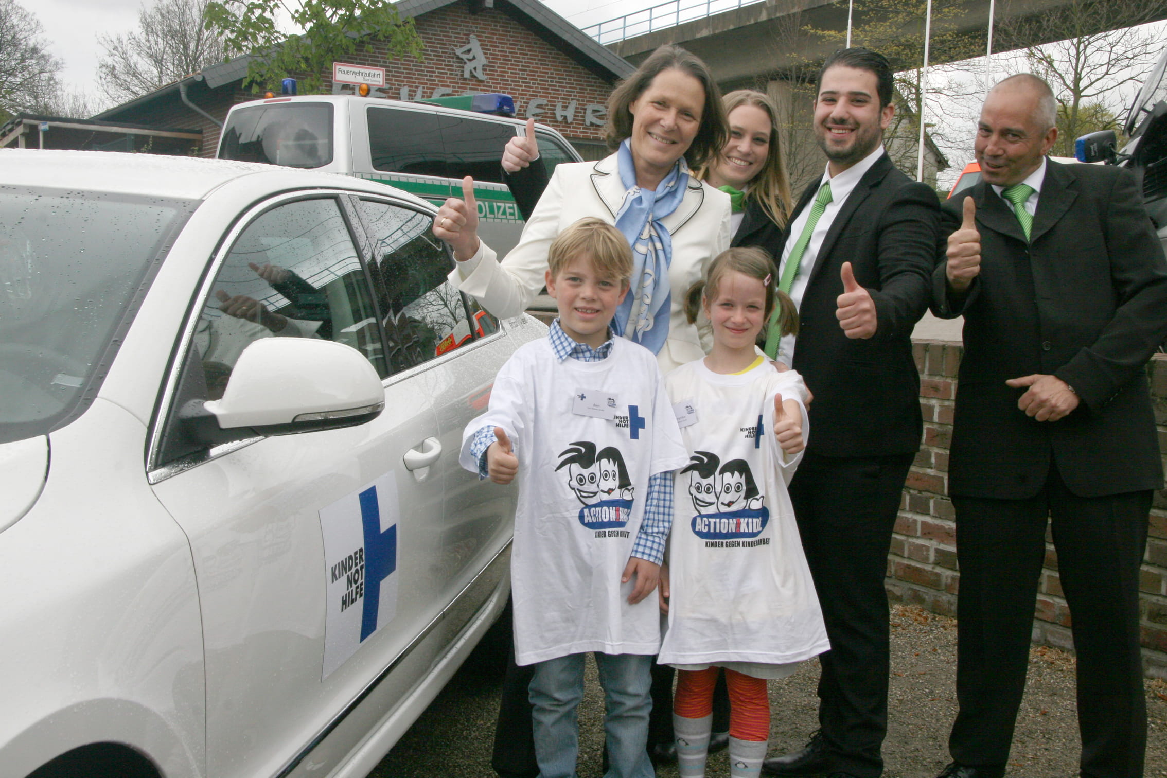 Christina Rau mit Action!Kidz und Mitarbeitern von Skoda vor einer Limousine von Skoda. (Quelle: Gunhild Aiyub)