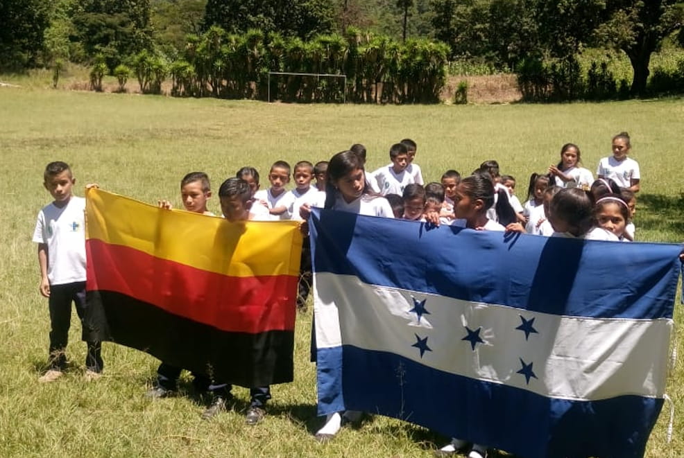 Patenbesuch Honduras ODECO/Limoncito: Kindergruppe auf Wiese mit Landesfahnen (Quelle: privat / Kindernothilfe) Patenbesuch Honduras ODECO/Limoncito: Kindergruppe auf Wiese mit Landesfahnen (Quelle: privat / Kindernothilfe)