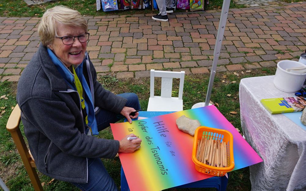 Reportage "Ein Dorf in Kindernothilfe-Hand"; Foto: Frau malt Plakat (Quelle: Ralf Krämer / Kindernothilfe) Reportage "Ein Dorf in Kindernothilfe-Hand"; Foto: Frau malt Plakat (Quelle: Ralf Krämer / Kindernothilfe)