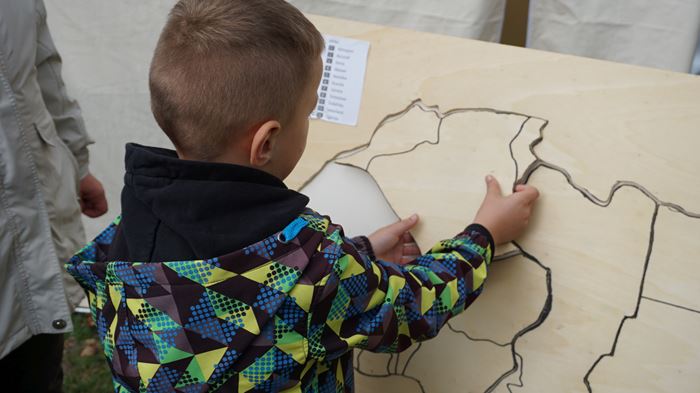 Reportage "Ein Dorf in Kindernothilfe-Hand"; Foto: Kind mit Afrika-Puzzle aus Holz (Quelle: Ralf Krämer / Kindernothilfe) Reportage "Ein Dorf in Kindernothilfe-Hand"; Foto: Kind mit Afrika-Puzzle aus Holz (Quelle: Ralf Krämer / Kindernothilfe)