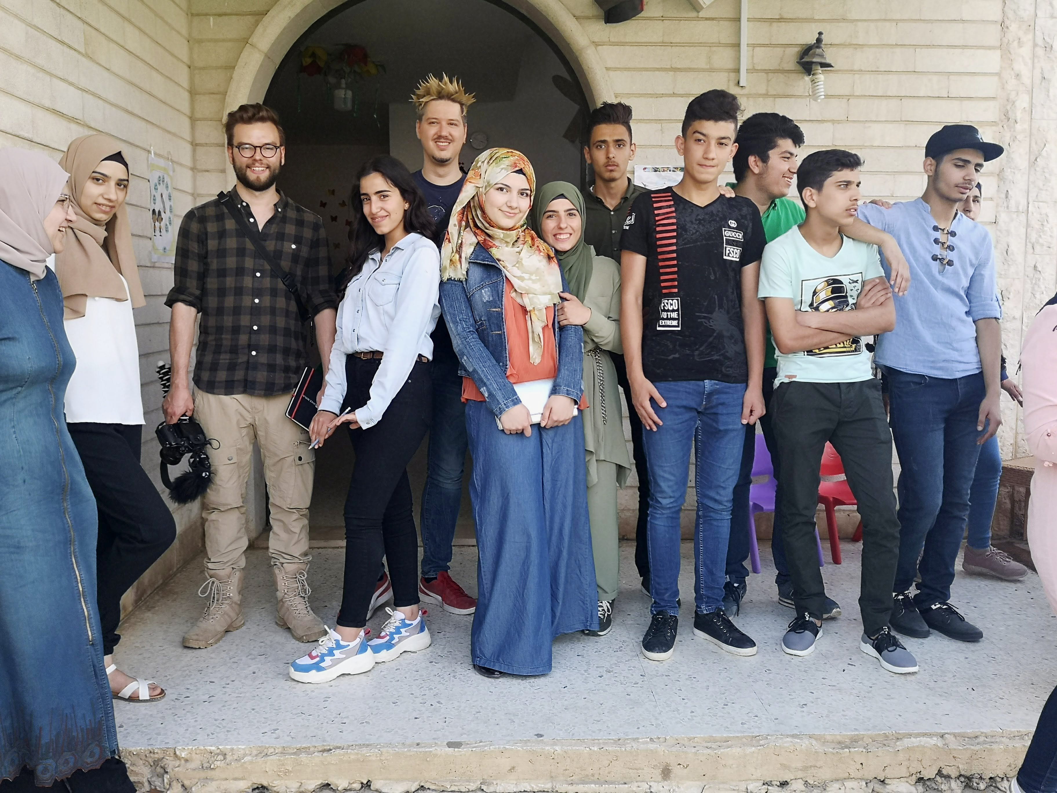 Reportage Libanon "Das Wichtigste ist eine Schule im Camp"; Gruppenfoto: Flo und Manniac mit Schülerinnen und Schülern (Quelle: Lorenz Toepperwien / Kindernothilfe)