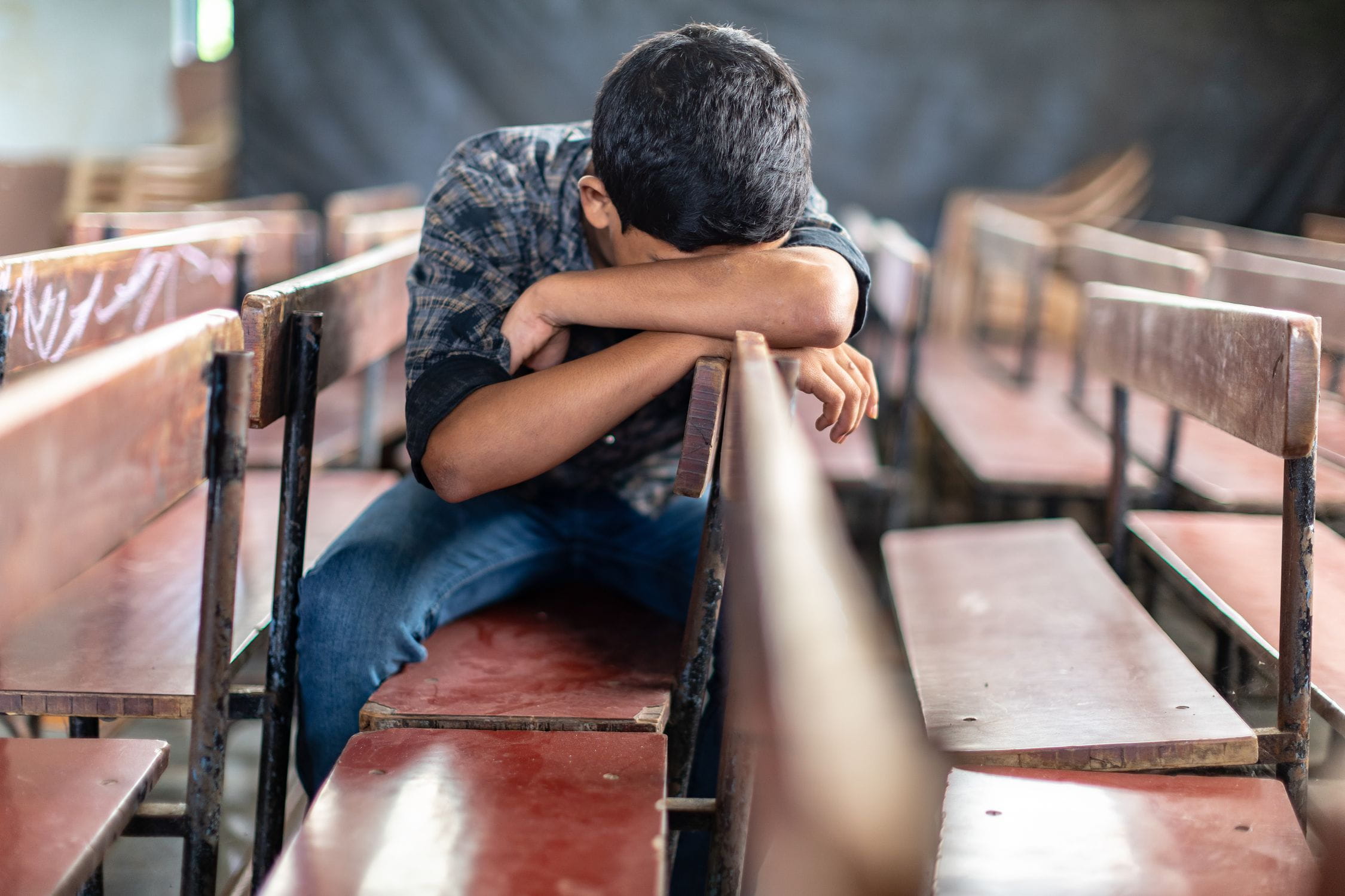 Ein Junge aus Indien vergräbt sein Gesicht in seinem Arm. (Quelle: Jakob Studnar)