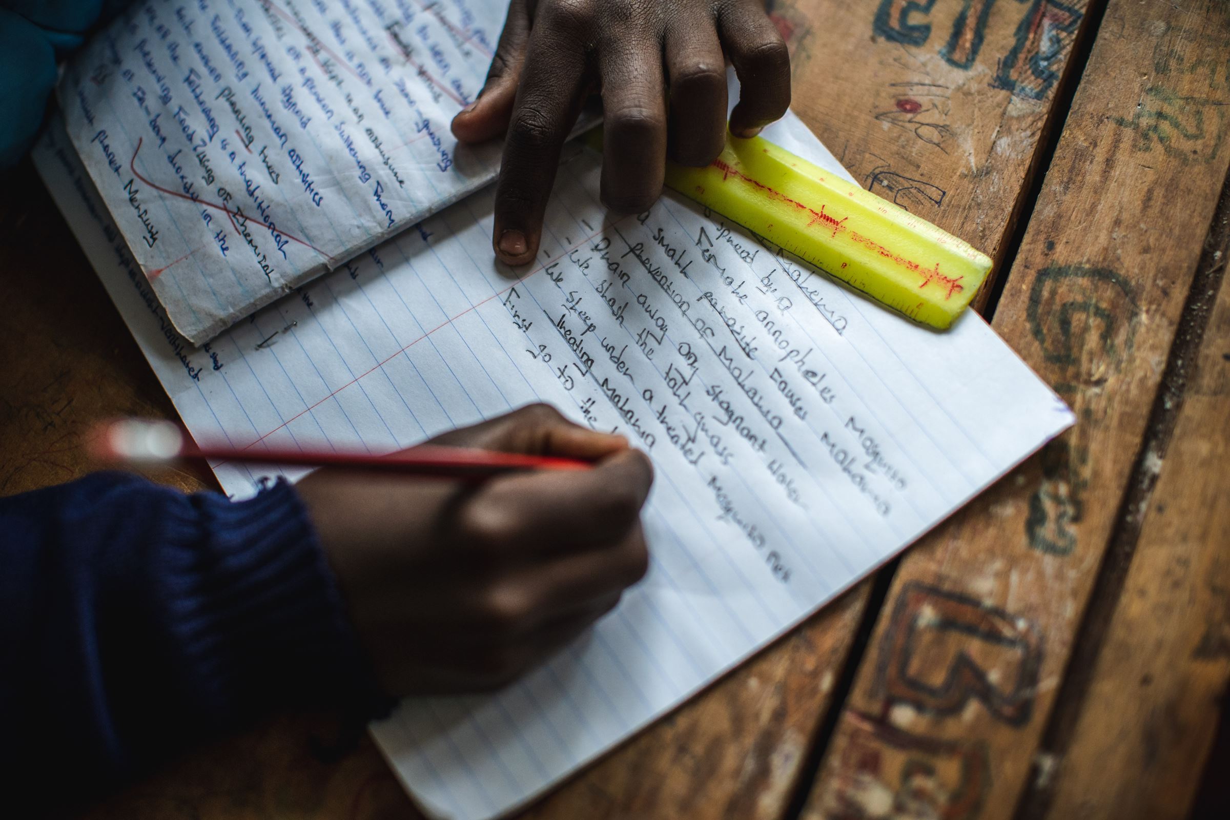 Ein Kind schreibt mit einem Bleistift in ein Heft und hält ein gelbes Lineal bereit. (Bildquelle: Lars Heidrich)