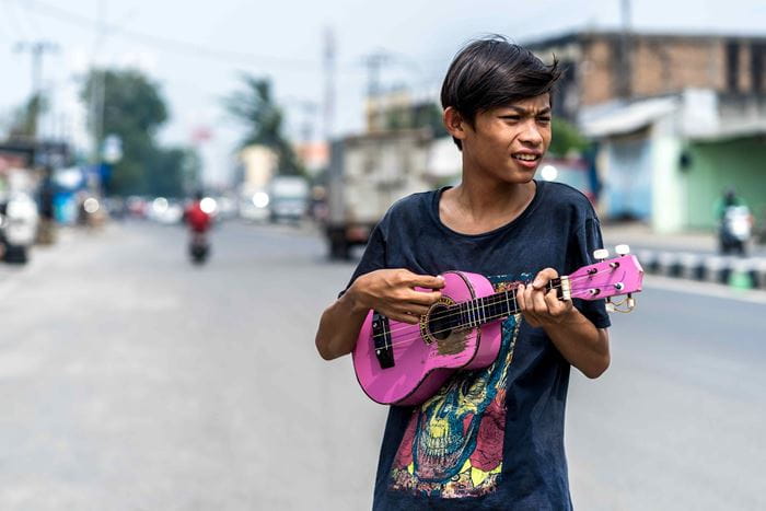 Ein Straßenmusiker mit einer pinkfarbenen Gitarre und ein Sänger (Quelle: Lennart Zech)