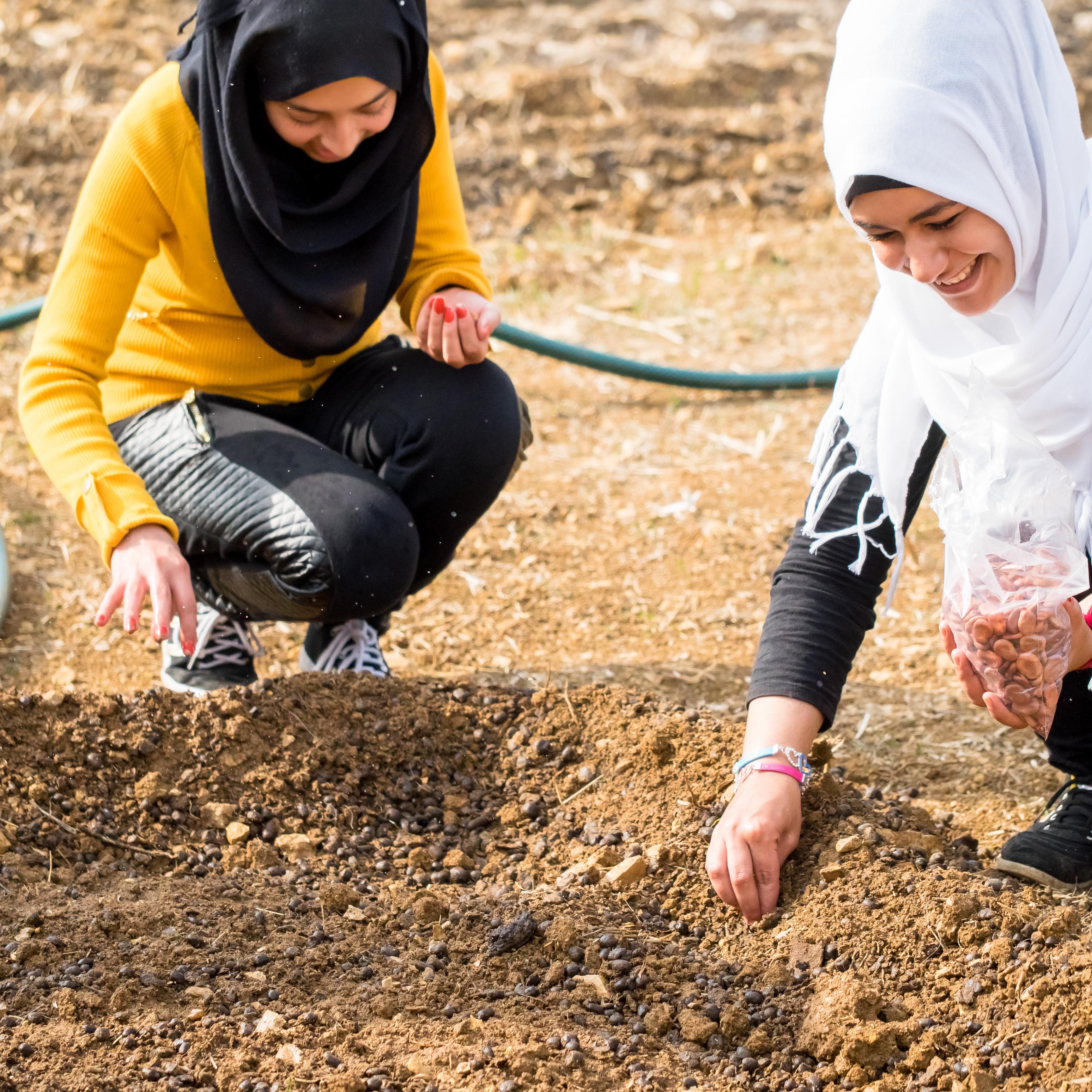 Zwei Frauen pflanzen Saatgut in die Erde (Quelle: Stephen Davies/Kindernothilfe)
